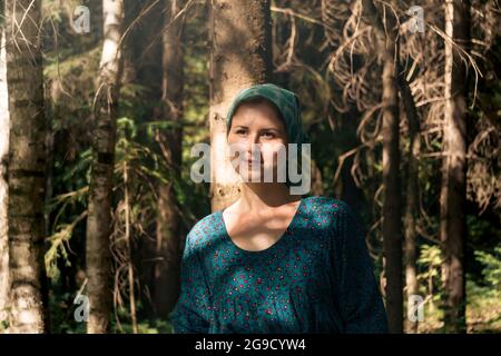 Porträt einer jungen Frau in volkstümlicher Bauernkleidung im Nadelwald Stockfoto