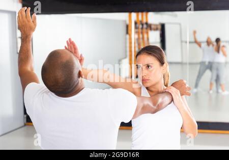 Frau und Mann beim Selbstschutztraining, Training der Angriffsbewegungen Stockfoto