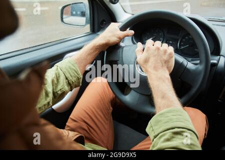 Nahaufnahme eines nicht erkennbaren Mannes, der Auto oder Van fährt, Fokus auf Hände am Lenkrad, Platz kopieren Stockfoto