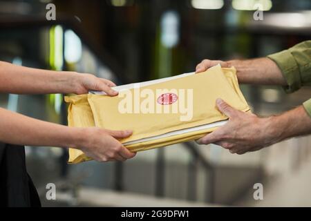 Seitenansicht Nahaufnahme eines nicht erkennbaren Zustellers, der Pakete an den Kunden übergab, Kopierraum Stockfoto