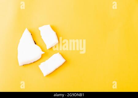 Happy Coconuts Tageskonzept, frische Kokosnuss Gruppe Stücke Scheiben, Studio Shot isoliert auf gelbem Hintergrund Stockfoto