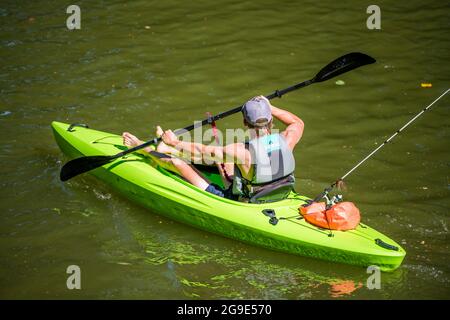 Sportlich fit muskulöse Fischer bevorzugen Outdoor-Aktivitäten für einen gesunden Lebensstil und paddeln mit dem Kajak auf dem Wasser eines Lacamas Lake, eingerahmt von einem Stockfoto