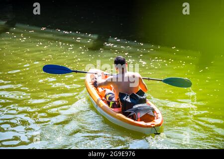 Sportlich fit muskulöse Männer bevorzugen Outdoor-Aktivitäten für einen gesunden Lebensstil, um die Gesundheit zu verbessern Ruhepaddeln auf dem Kajak auf dem Wasser eines Lacamas Lake Fra Stockfoto