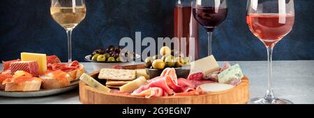 Italienische Antipasti oder spanische Tapas-Panorama mit Wein, Wurst und Käse. Rose, Weiß- und Rotwein, eine Gourmet-Wurstwaren und Käseplatte sowie Crostini mit parma Stockfoto