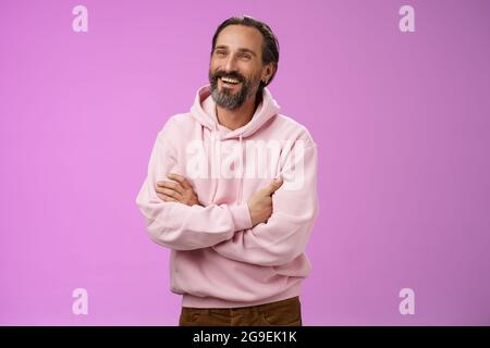 Prooud erfolgreiche verträumt glücklich Erwachsenen bärtigen Mann Urlaub genießen sorglos Leben lachen glücklich Kreuz Arme Brust zuversichtlich Blick zur Seite erreicht Stockfoto