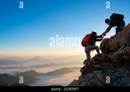 Asien paar Wandern helfen einander auf Berge Blick . Teamwork Stockfoto