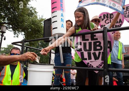 Washington, DC, USA, 25. Juli 2021. Im Bild: Ein Mitglied der CODEPINK sammelt Spenden bei einer Kundgebung zur Feier der Ankunft von Puentes de Amor (Bridges of Love)-Marschern, die 1300 Meilen von Miami nach Washington, DC, gelaufen sind und die USA aufforderten, ihre Blockade von Kuba zu beenden. CODEPINK hat kürzlich 500 000 Milliarden für den Kauf von 6 Millionen Spritzen für das kubanische Volk zur Bekämpfung von Covid-19 gesammelt und auf der Kundgebung Spenden für Medikamente und medizinische Hilfsgüter angenommen, um die gesundheitlichen Auswirkungen der US-Blockade abzustumpfen. Kredit: Allison Bailey / Alamy Live Nachrichten Stockfoto