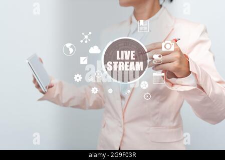 Hand schreiben Zeichen Live Stream. Wort für die Übertragung eines Video- oder Audiomaterials mit dem Einsatz von Internet Business Woman Touching Digital Data On Stockfoto