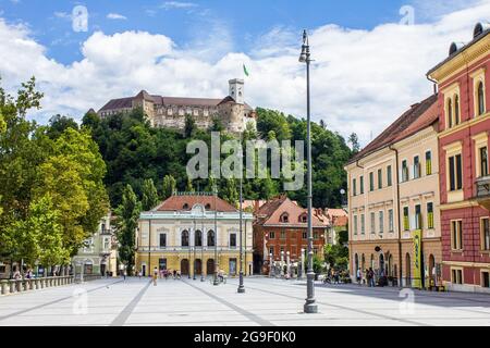 Ljubljana, Slowenien - 15. Juli 2017: Philharmonisches Gebäude auf dem Kongressplatz mit der Burg von Ljubljana im Hintergrund Stockfoto