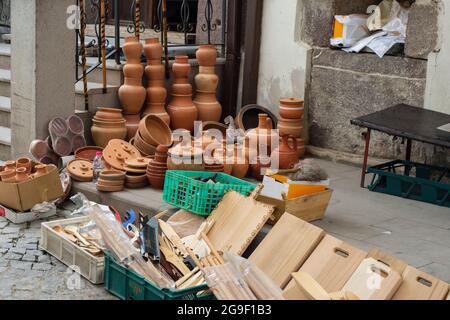 Authentische Produkte des Straßenverkäufers. Handgemachte Holzschneidebretter, Holzlöffel, Tontöpfe in verschiedenen Formen und Größen. Stockfoto