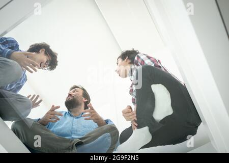 Niedriger Winkel des Vaters und der Söhne, die auf Glas sitzen Stockfoto