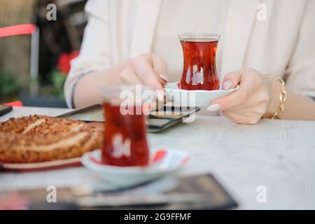 Frau trinkt köstlichen traditionellen türkischen Tee im Café. Hochwertige Fotos Stockfoto