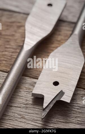 Federholz-Bohrer auf Holzhintergrund. Bohrer für Holz auf natürlichem Holzhintergrund. Hintergrund der Holzbearbeitung. Stockfoto