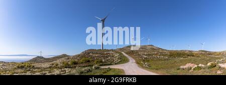 Ultra Panoramablick auf die Pisao Berge, mit Windturbinen und blauen Himmel als Hintergrund, in Portugal Stockfoto