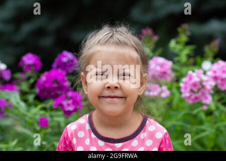 Porträt von lustigen schielenden Augen kaukasischen Mädchen von vier Jahren Blick auf die Kamera im Sommer Park Stockfoto