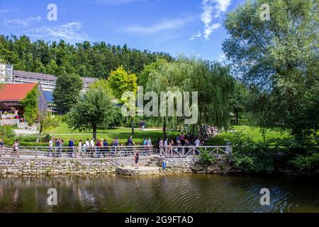 Postojna, Slowenien - 16. Juli 2017: Blick auf Touristen, die durch Postojna mit dem Hotel Jama im Hintergrund wandern Stockfoto