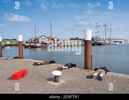 Alte hölzerne Segelschiffe im Hafen von oudeschild auf der niederländischen Insel texel, während die Menschen nach Krabben fischen und der Mensch fotografiert Stockfoto