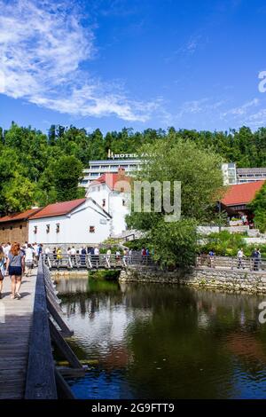 Postojna, Slowenien - 16. Juli 2017: Blick auf Touristen, die durch Postojna mit dem Hotel Jama im Hintergrund wandern Stockfoto