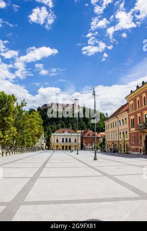 Ljubljana, Slowenien - 15. Juli 2017: Philharmonisches Gebäude auf dem Kongressplatz mit der Burg von Ljubljana im Hintergrund Stockfoto