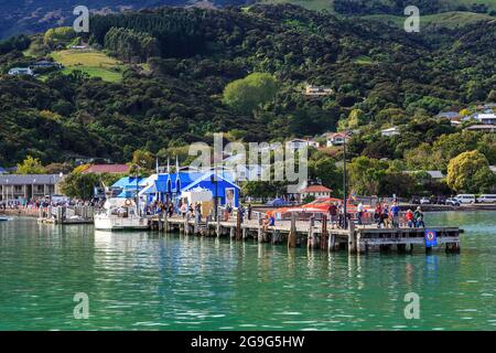 Akaroa, Neuseeland. Der historische Hauptwharf, an dem Passagiere von Kreuzfahrtschiffen aussteigen, um diese Touristenstadt zu besuchen Stockfoto