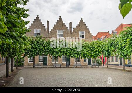 Vlissingen, Niederlande, 24. Juli 2021: vierwinden-Platz in der Altstadt, umgeben von geformten Bäumen und historischen Fassaden Stockfoto