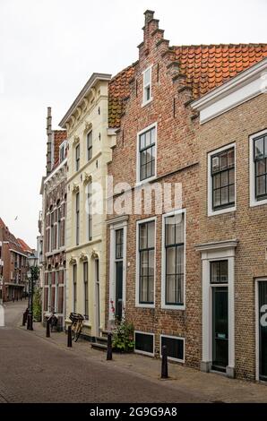 Vlisssingen, Niederlande, 24. Juli 2021: Kurvige Straße in der Altstadt, gesäumt von traditionellen Backstein- und Gipsfassaden Stockfoto