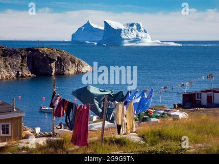 Ein großer Eisberg, der in einer Bucht vor der Westküste von Qeqertarsuaq, Grönland, mit einer Wäscheleine im Vordergrund und Trocknung der Kleidung, gegründet wurde Stockfoto