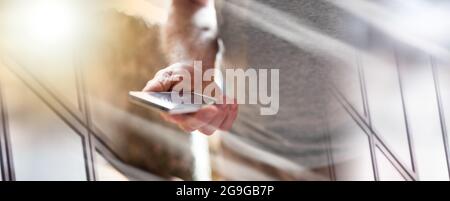 Mann steht mit seinem Smartphone; Mehrfachbelichtung Stockfoto