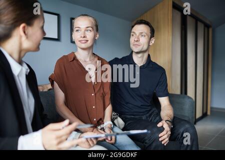 Porträt eines jungen Paares, das mit einem Immobilienmakler spricht, während er ein neues Haus kauft, Platz kopiert Stockfoto