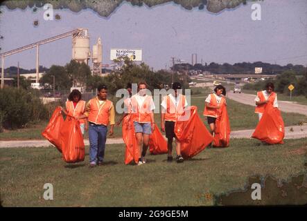 New Braunfels Texas USA: Freiwillige im Teenageralter tragen leuchtend orange reflektierende Westen, während sie Müll am Straßenrand aufsammeln. ©Bob Daemmrich Stockfoto