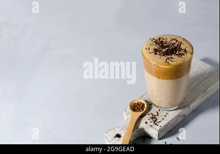 Kalter Kaffee in einem hohen Glas auf einem Holzbrett mit Kopiertext Stockfoto