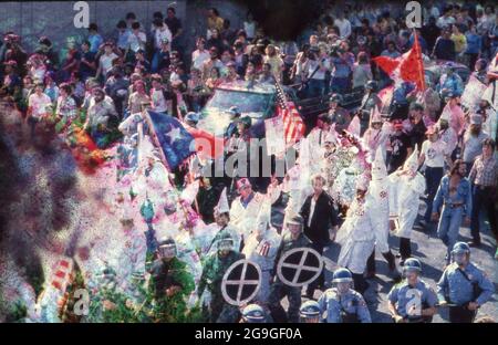 Austin, Texas, USA, um 1983: Eine kleine Gruppe von Ku Klux Klan-Mitgliedern, flankiert von der Polizei, zieht durch die Innenstadt von Austin, wo sie von einer feindlichen Anti-KKK-Menge getroffen werden. ©Bob Daemmrich Stockfoto