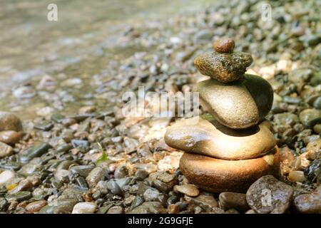 Steinpyramide im japanischen Stil am Flussufer. Meditation. Entspannen Sie Sich. Gelassenheit Stockfoto