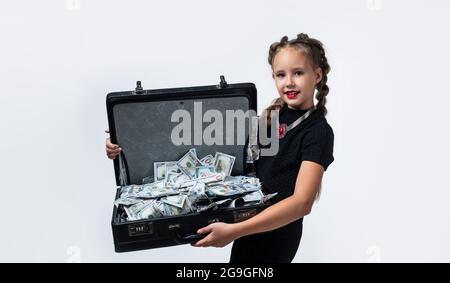 Hübsches Teenager-Mädchen mit Zöpfen hat viel Geld im Koffer isoliert auf weiß, Geld Stockfoto