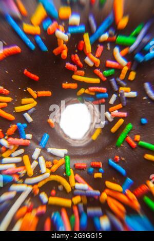 Makroextreme Nahaufnahme eines mit Schokoladenzuckerguss bestreuten Donuts Stockfoto