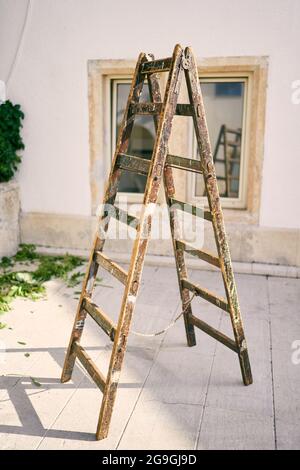Holztreppe steht auf einer Fliese im Innenhof des Hauses Stockfoto