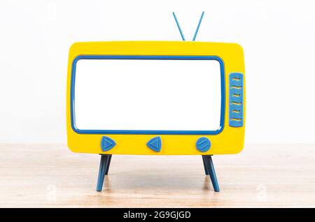 Vintage Miniatur-Spielzeug-Fernseher auf Holztisch. Stockfoto