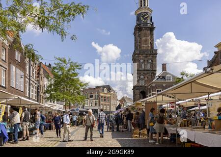 ZUTPHEN, NIEDERLANDE - 25. Jul 2021: Marktplatz mit Buchmesse während der COVID-19 Pandemie mit Wijnhuistoren, die im Hintergrund mit blauem Himmel aufragen Stockfoto