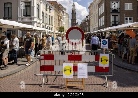 ZUTPHEN, NIEDERLANDE - 25. Jul 2021: Gesundheitsmessungen auf einer Buchmesse während der COVID-19-Pandemie mit Wijnhuistoren im Hintergrund. Stockfoto