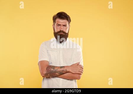 Haar- und Bartpflege. Bärtiger Koch in weißem Hemd. Brutaler kaukasischer Hipster mit Schnurrbart. Selbstbewusster und gutaussehender brutaler Mann. Charismatischer Kerl, der aussieht Stockfoto