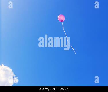 Echt Spaß rosa Ballon auf blauem Himmel sonnigen Tag Hintergrund Stockfoto