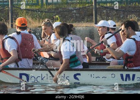 Barristers, die im Rahmen einer von Brick Court Chambers organisierten Spendenaktion an einem Drachenbootrennen im Docklands Sailing and Watersport Centre teilnehmen Stockfoto