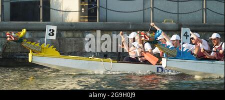 Barristers, die im Rahmen einer von Brick Court Chambers organisierten Spendenaktion an einem Drachenbootrennen im Docklands Sailing and Watersport Centre teilnehmen Stockfoto