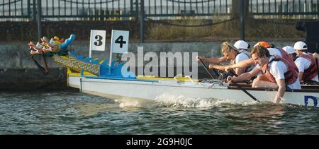 Barristers, die im Rahmen einer von Brick Court Chambers organisierten Spendenaktion an einem Drachenbootrennen im Docklands Sailing and Watersport Centre teilnehmen Stockfoto