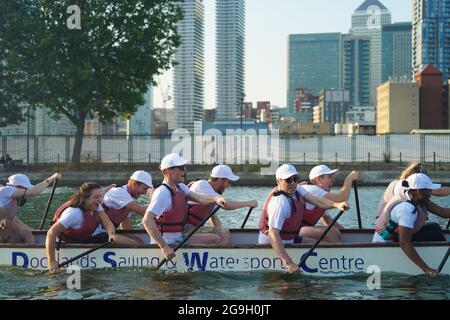 Barristers, die im Rahmen einer von Brick Court Chambers organisierten Spendenaktion an einem Drachenbootrennen im Docklands Sailing and Watersport Centre teilnehmen Stockfoto