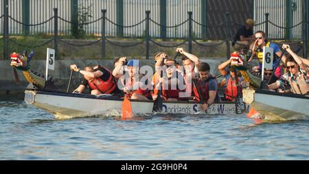 Barristers, die im Rahmen einer von Brick Court Chambers organisierten Spendenaktion an einem Drachenbootrennen im Docklands Sailing and Watersport Centre teilnehmen Stockfoto