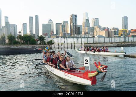 Barristers, die im Rahmen einer von Brick Court Chambers organisierten Spendenaktion an einem Drachenbootrennen im Docklands Sailing and Watersport Centre teilnehmen Stockfoto