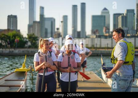 Barristers, die im Rahmen einer von Brick Court Chambers organisierten Spendenaktion an einem Drachenbootrennen im Docklands Sailing and Watersport Centre teilnehmen Stockfoto