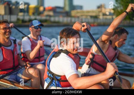 Barristers, die im Rahmen einer von Brick Court Chambers organisierten Spendenaktion an einem Drachenbootrennen im Docklands Sailing and Watersport Centre teilnehmen Stockfoto