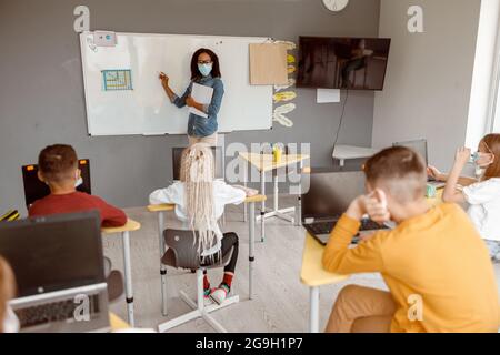 Schüler, die während des Unterrichts an ihrem Schreibtisch sitzen Stockfoto